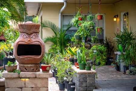 Chiminea that looks like a face next to plants at The Yard